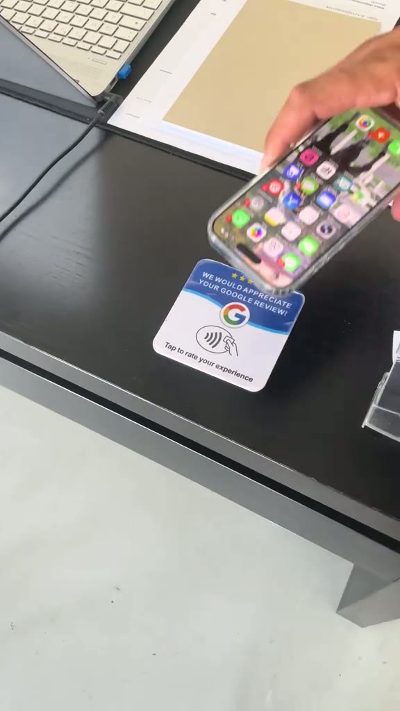 Placa POG REVIEW sendo aproximada de um celular para avaliar no Google